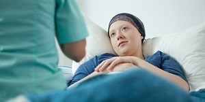 Girl with cancer looks at doctor